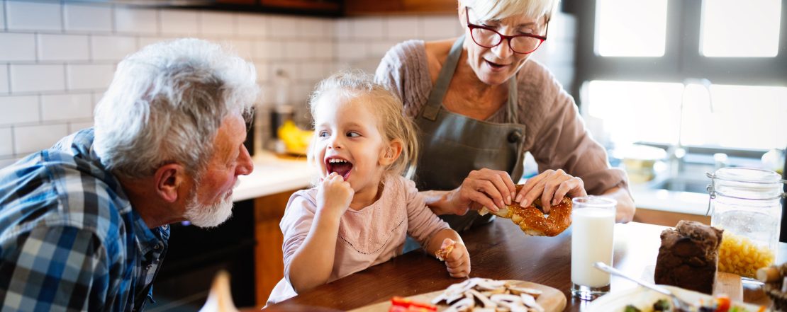 Happy smiling grandparents playing with their granddaughter