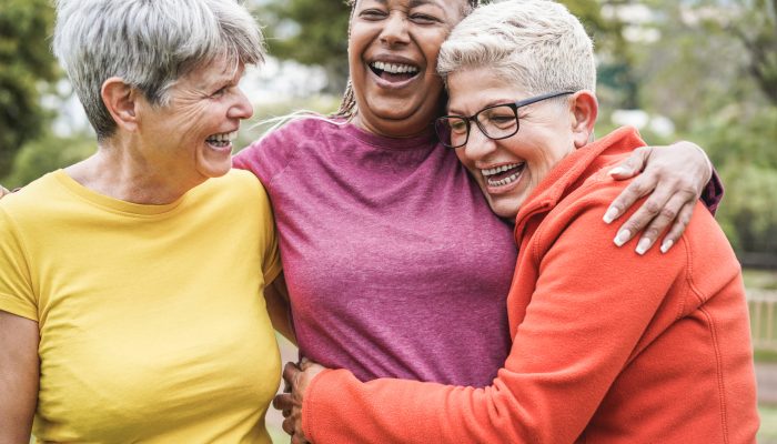 Multiracial senior women having fun together after sport workout outdoor - Main focus on african female face